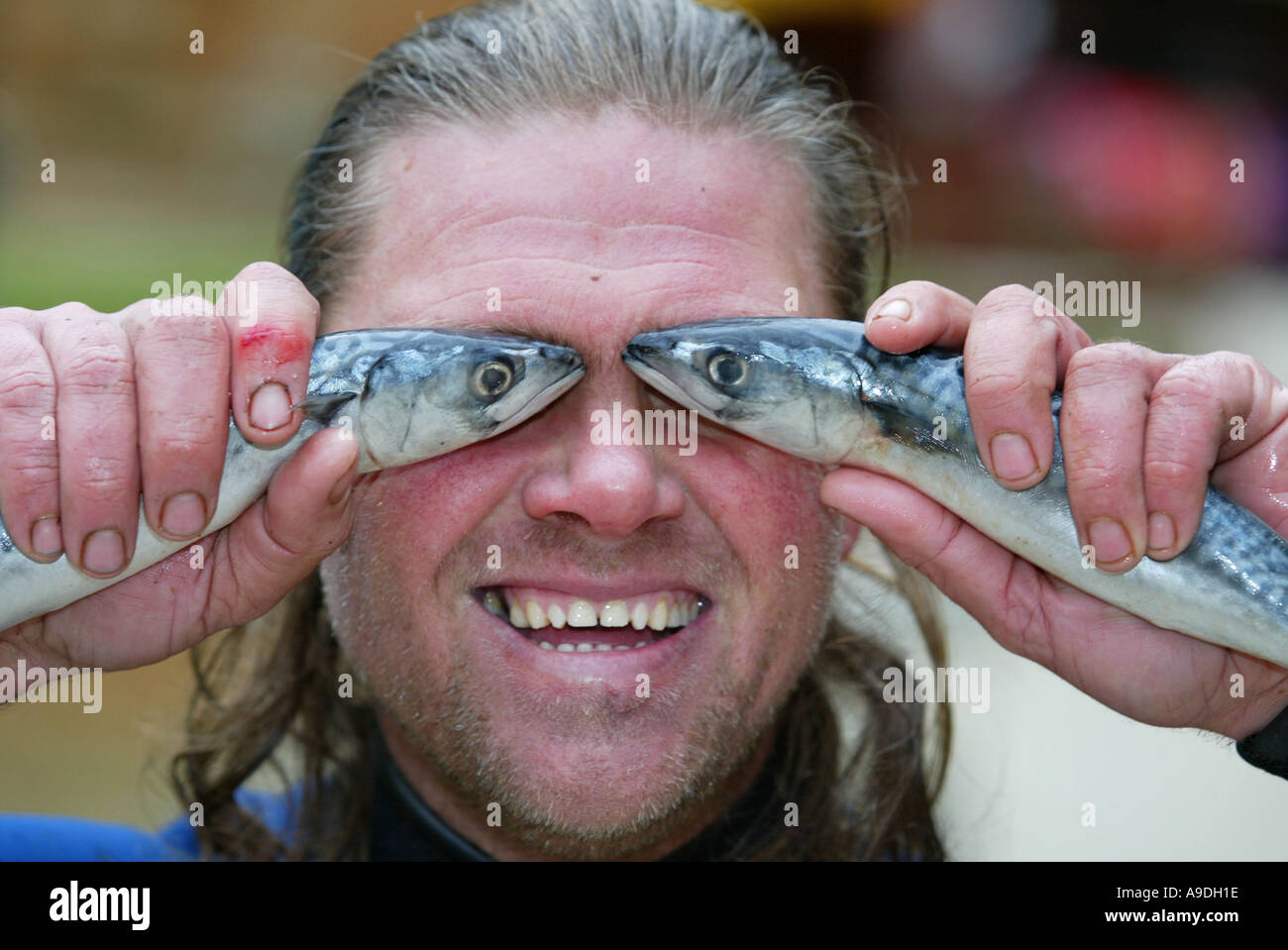 man-holding-up-fishes-fish-eyes-A9DH1E.jpg