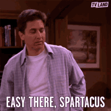 a man says  easy there spartacus  while standing in front of a bookshelf