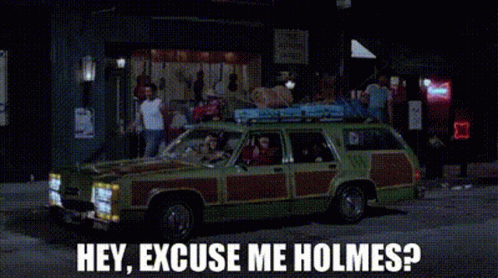 a green car is parked on the side of the road and says hey excuse me holmes ?