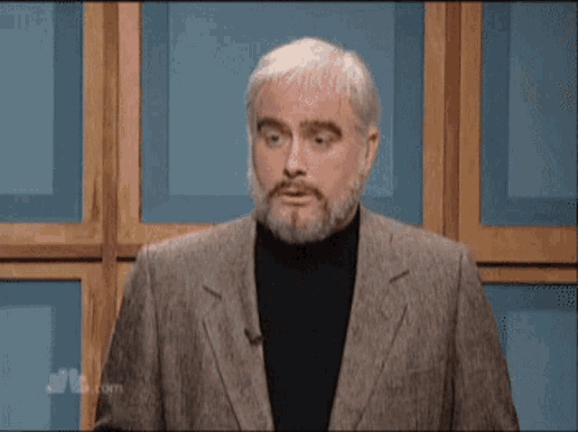 a man with a beard says  moo  while standing in front of a wooden wall