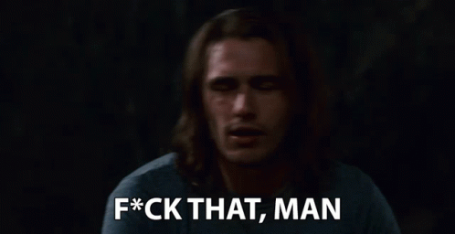 a man with long hair says f * ck that man in a dark room